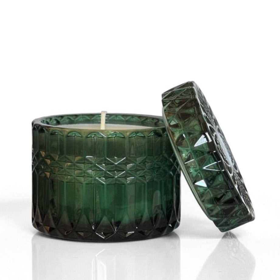 Green textured candle with lid on a white background