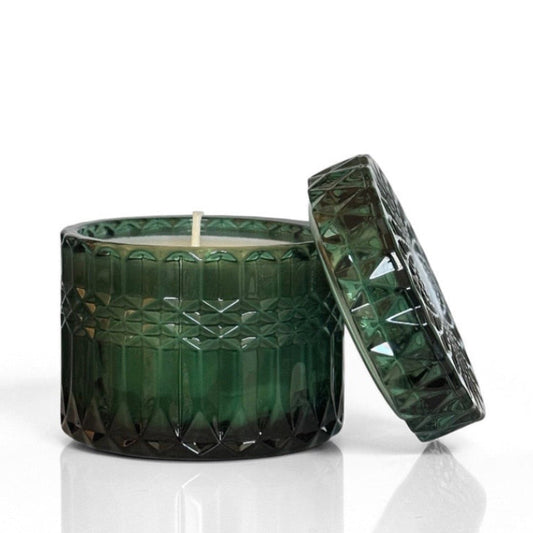 Green textured candle with lid on a white background