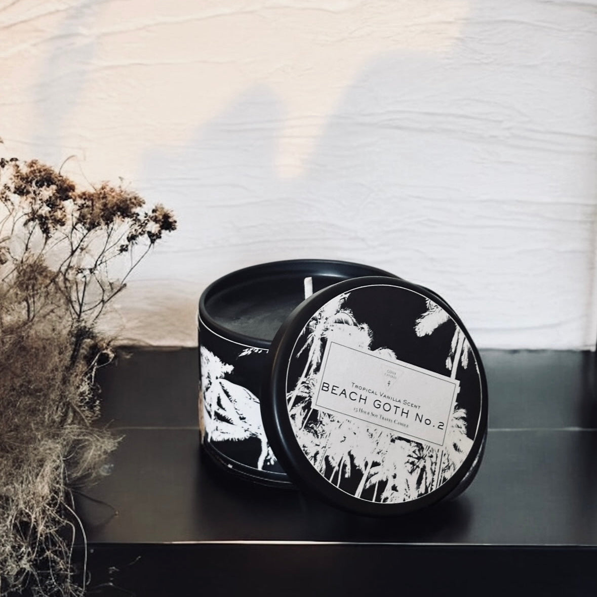 Black candle tin with white design on a black surface