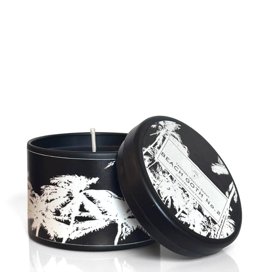 Black candle with white floral design and matching lid on a white background