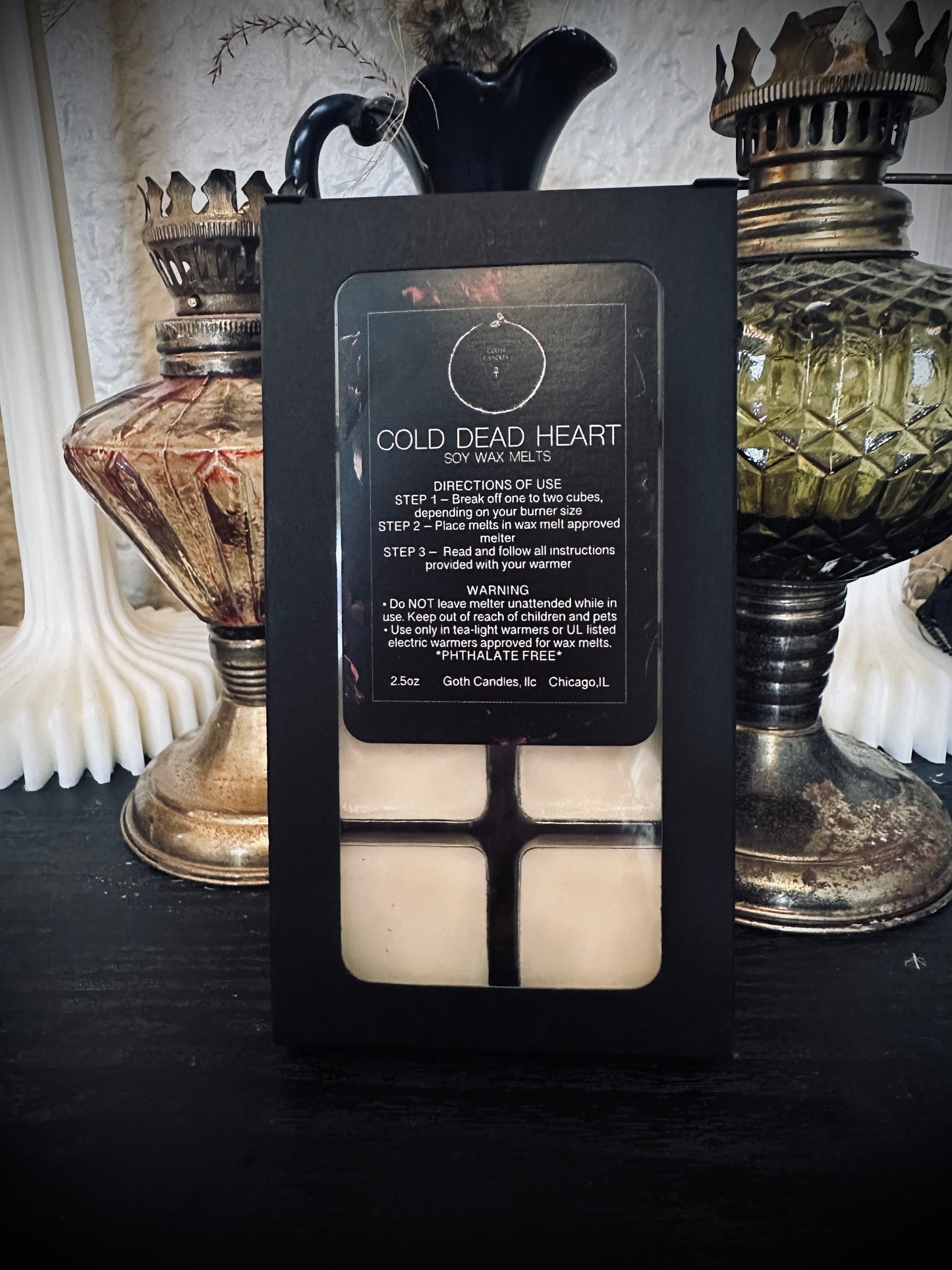 Candle packaging for 'Cold Dead Heart' with decorative background