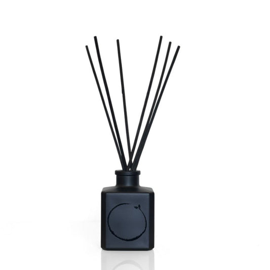 Black reed diffuser with sticks on a white background