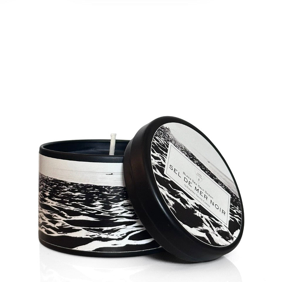 Candle in a decorative container with a beach print design on a white background